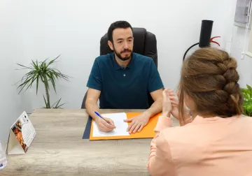 Conversación entre fisioterapeuta y paciente en la consulta